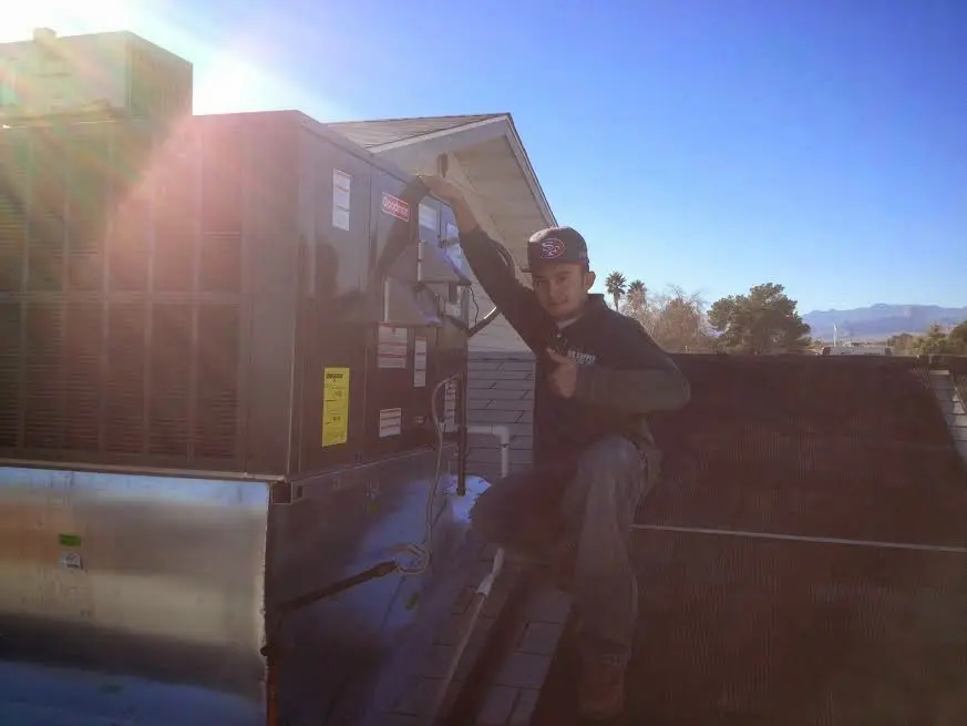 HVAC technician performing Heat Pump Repair on a rooftop unit in Mayo